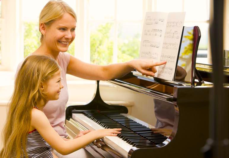Piano Teacher and Girl sitting at piano lesson